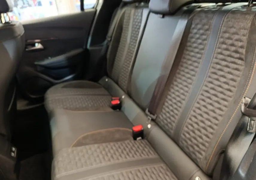 Vue intérieure côté droit sur la banquette arrière gris foncé avec surpiqûres orange de la Peugeot 208 Electrique Roadtrip 2022.