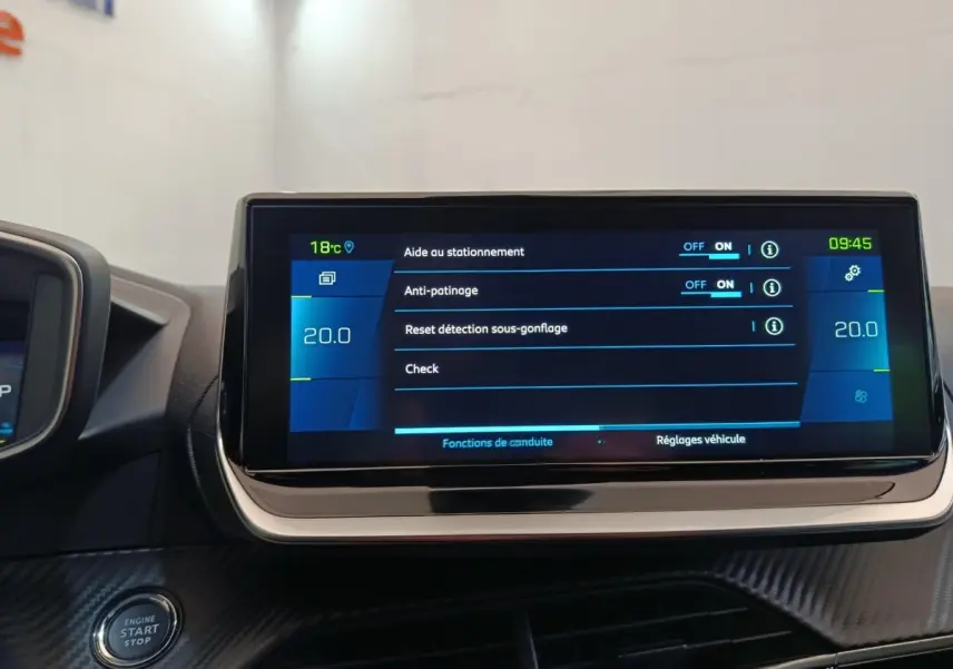 Écran tactile central affichant les réglages d’aide à la conduite dans une Peugeot 208 Electrique gris clair, vue intérieure frontale.