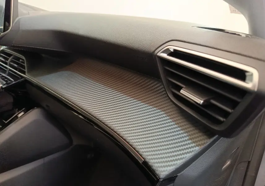 Vue intérieure côté passager du tableau de bord gris foncé avec finition carbone du Peugeot 208 Electrique ROADTRIP 2022.