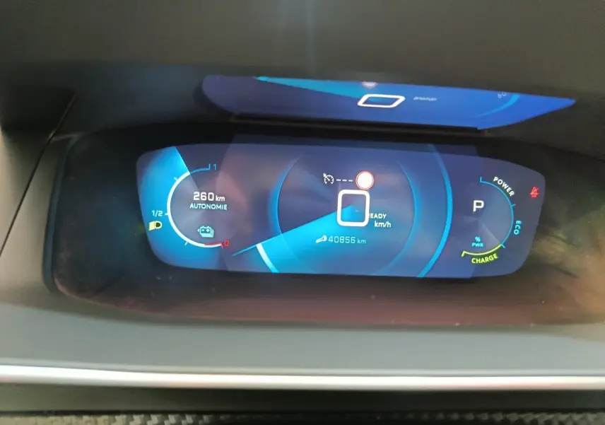 Affichage numérique du tableau de bord de la Peugeot 208 Electrique ROADTRIP 2022 montrant l'autonomie et la vitesse.