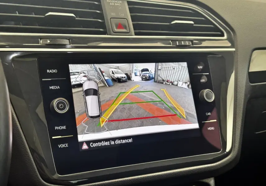 Écran tactile central du Volkswagen Tiguan 2021 montrant la caméra de recul avec guidage de trajectoire coloré.