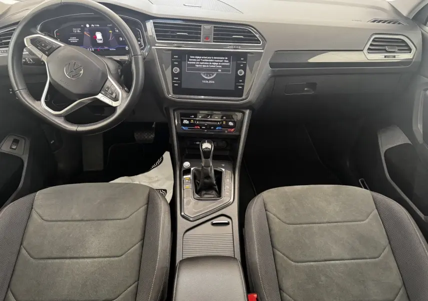 Vue intérieure frontale du Volkswagen Tiguan 1.5 TSI 150 DSG7 Elegance 2021, sièges tissu gris et tableau de bord digital.