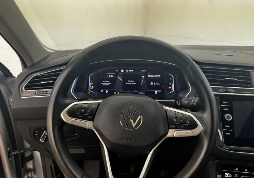 Vue intérieure centrée sur le volant cuir noir et le tableau de bord numérique du Volkswagen Tiguan gris clair 2021.