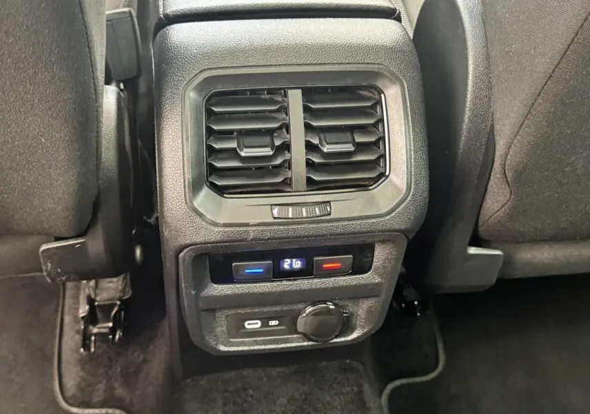 Vue rapprochée de la console arrière noire du Volkswagen Tiguan 1.5 TSI 150 DSG7 Elegance avec ventilation et commandes de climatisation digitales.