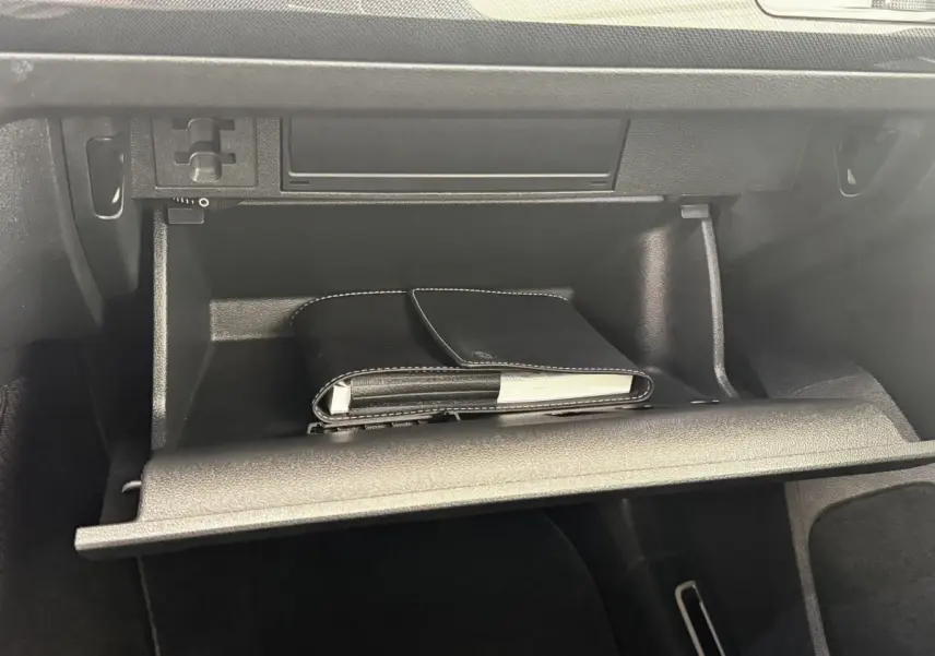 Gant de poche noir dans la boîte à gants ouverte du Volkswagen Tiguan 1.5 TSI 150 DSG7 Elegance 2021.