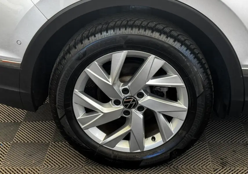 Gros plan sur la roue avant droite gris clair du Volkswagen Tiguan 1.5 TSI 150 DSG7 Elegance avec jante alliage distinctive.