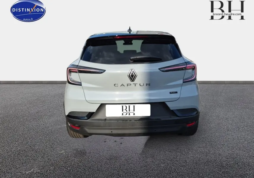 Vue arrière d'une Renault Captur blanche avec feux arrière LED et logo central bien visible.