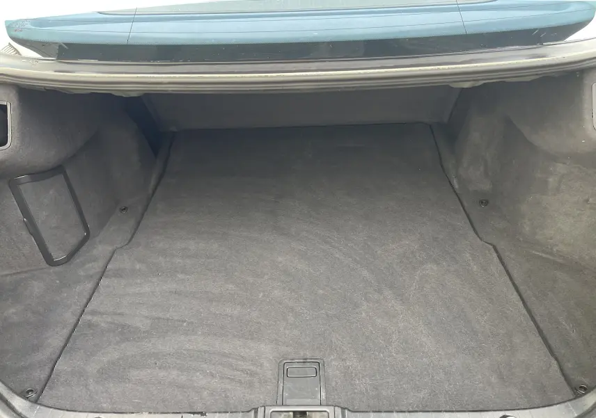 Coffre ouvert vu de face d'une Mercedes Classe E 320 CDI Elegance noire de 2003, intérieur du coffre propre et vide.