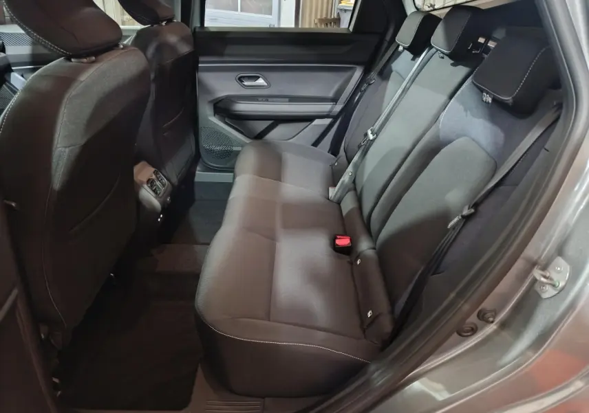 Vue intérieure côté droit sur la banquette arrière noire du Dacia Bigster gris foncé avec ceinture et appuie-têtes visibles.