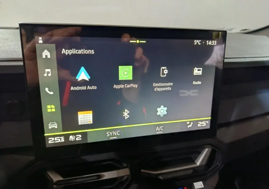 Écran tactile central affichant les applications Apple CarPlay et Android Auto dans l'habitacle du Dacia Bigster gris foncé.