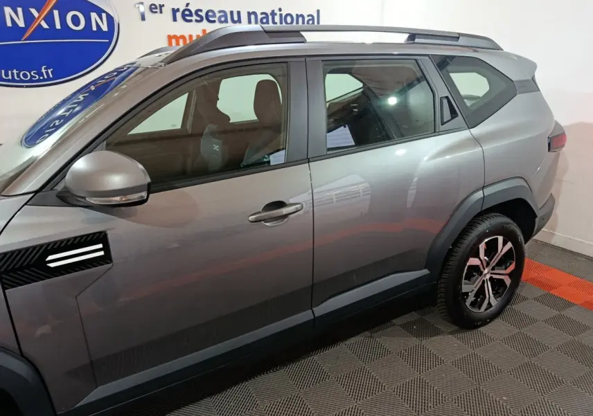 Vue latérale côté gauche du Dacia Bigster gris foncé avec jantes alliage et rétroviseurs électriques intégrés.