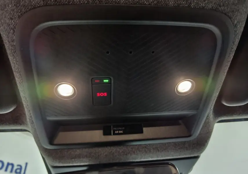 Vue intérieure du plafonnier avec éclairages et bouton SOS rouge allumé sur Dacia Bigster gris foncé.