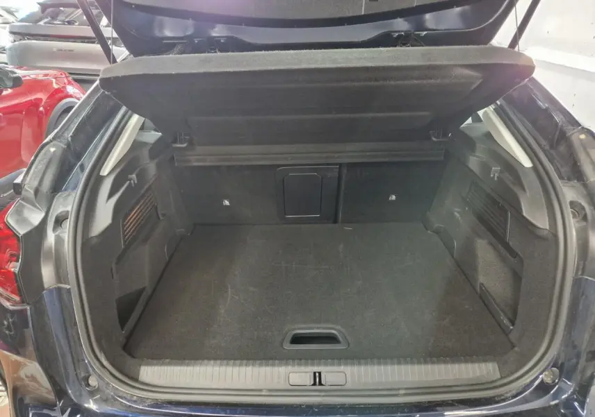 Coffre ouvert vu de l'arrière d'une Citroën C4 2024 bleu Eclipse avec toit noir Perla, intérieur noir.