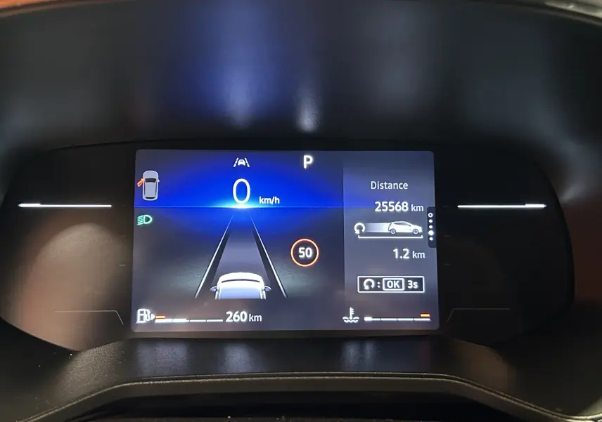 Tableau de bord numérique de Renault Clio V blanc, affichant vitesse à 0 km/h et distance parcourue 25 568 km.