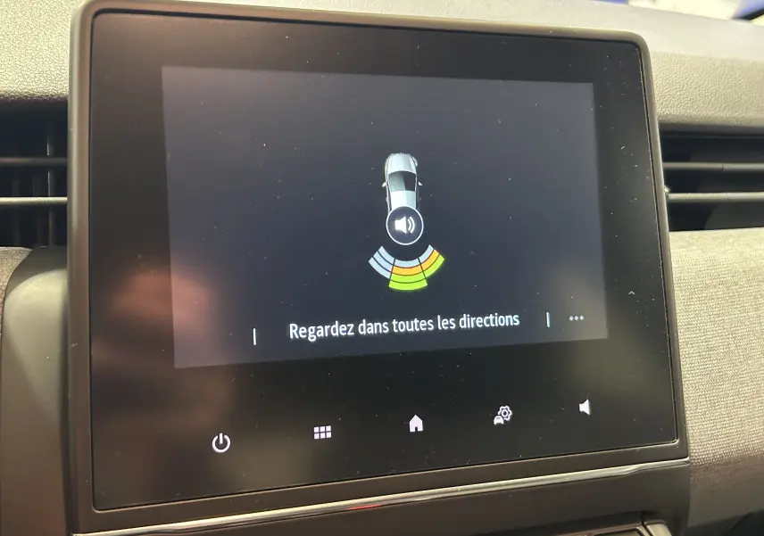 Écran tactile central de la Renault Clio V blanc montrant l'alerte radar de proximité avec instructions en français.