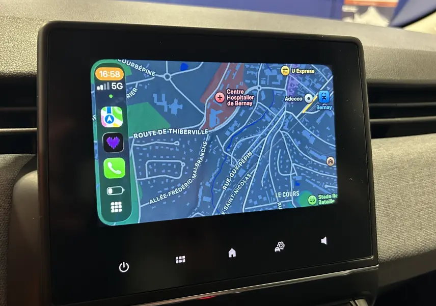 Écran tactile central affichant la navigation avec Apple CarPlay dans une Renault Clio V 2025, intérieur noir.