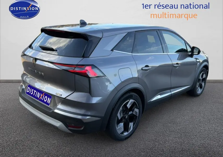 Vue 3/4 arrière droite d'un Renault Symbioz gris métallisé avec vitres surteintées et barres de toit visibles.