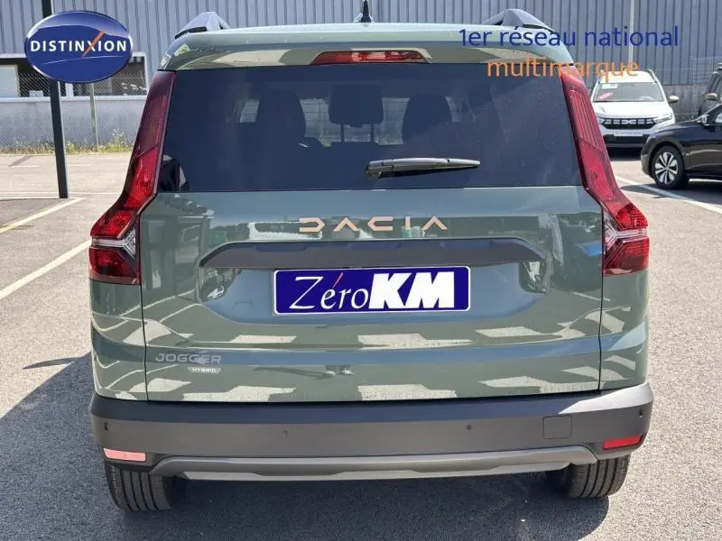 Vue arrière d'un Dacia Jogger hybride vert kaki avec feux arrière verticaux et lunette arrière teintée.