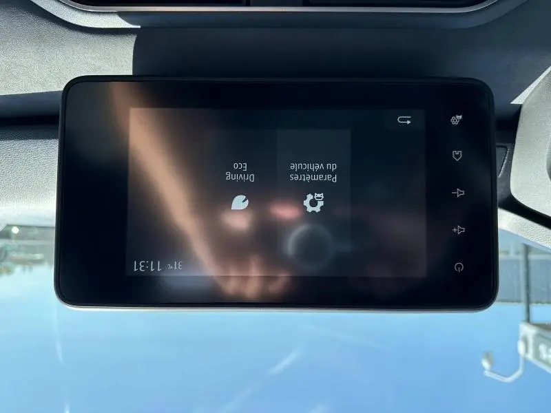 Écran tactile central du tableau de bord du Dacia Jogger blanc, affichant les paramètres du véhicule en mode ECO.