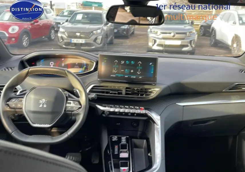 Vue intérieure du tableau de bord et volant cuir multifonction du Peugeot 3008 hybride 2024, avec écran tactile central.