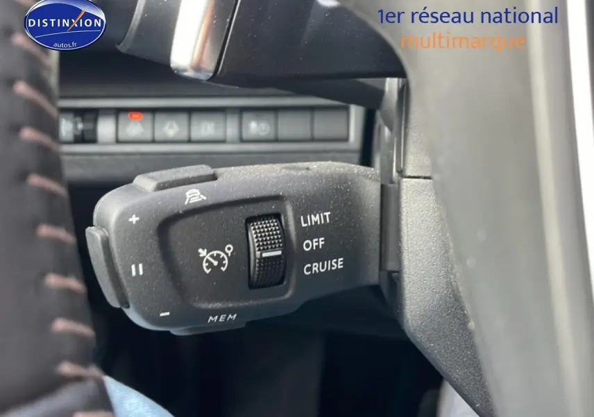 Gros plan sur la commande de régulateur de vitesse au volant d’un Peugeot 3008 bleu 2024 hybride.