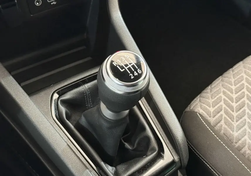Le levier de vitesses manuel noir de la Renault Clio Evolution TCe 100 GPL, avec indication des 6 rapports, vue rapprochée intérieure.