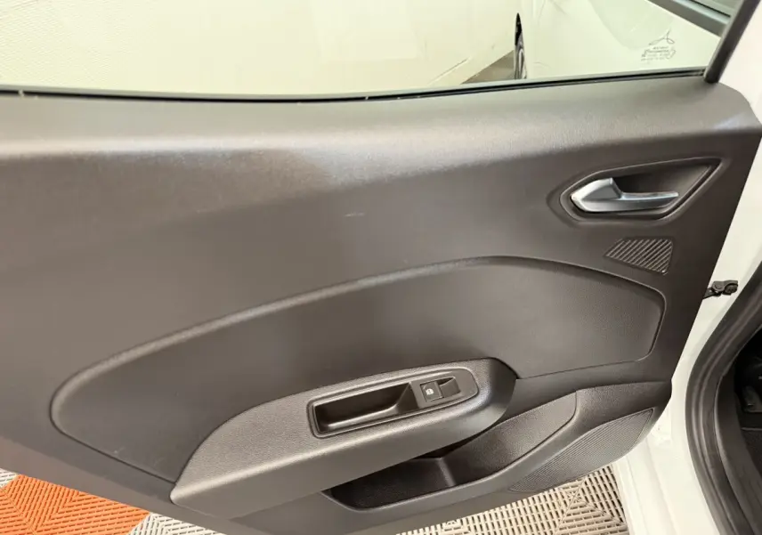 Vue intérieure de la porte arrière droite noire d'une Renault Clio blanche Evolution TCe 100 GPL 2023.