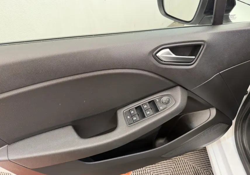 Intérieur côté conducteur de la Renault Clio blanc 2023, montrant la porte avec commandes des vitres et rétroviseur.
