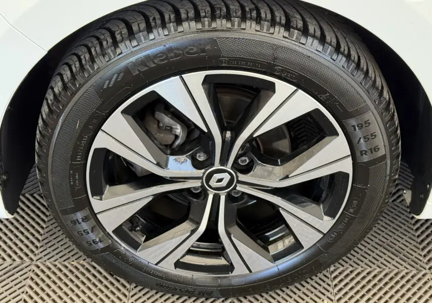 Gros plan sur la jante alliage bicolore et pneu Kleber d’une Renault Clio blanche, côté avant droit.