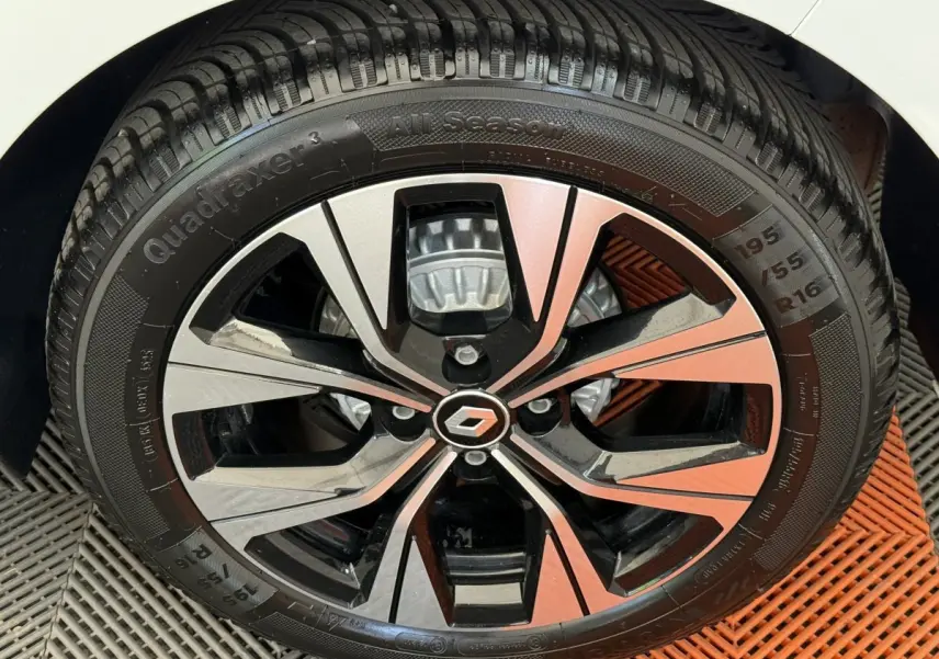 Gros plan sur la jante alliage bicolore noire et argentée de la Renault Clio blanche Evolution TCe 100 GPL.