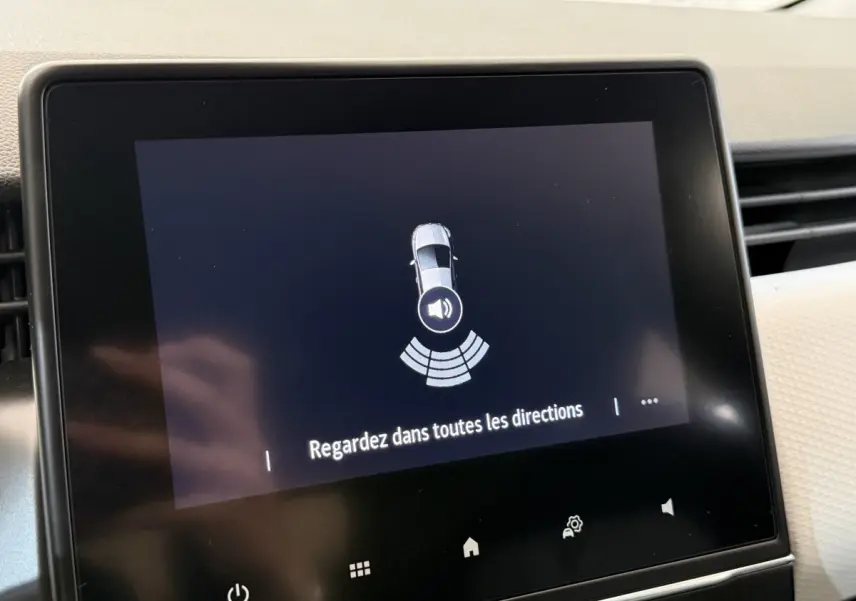 Écran tactile central de Renault Clio 2023 affichant l'alerte de détection d'obstacles avec message de sécurité.