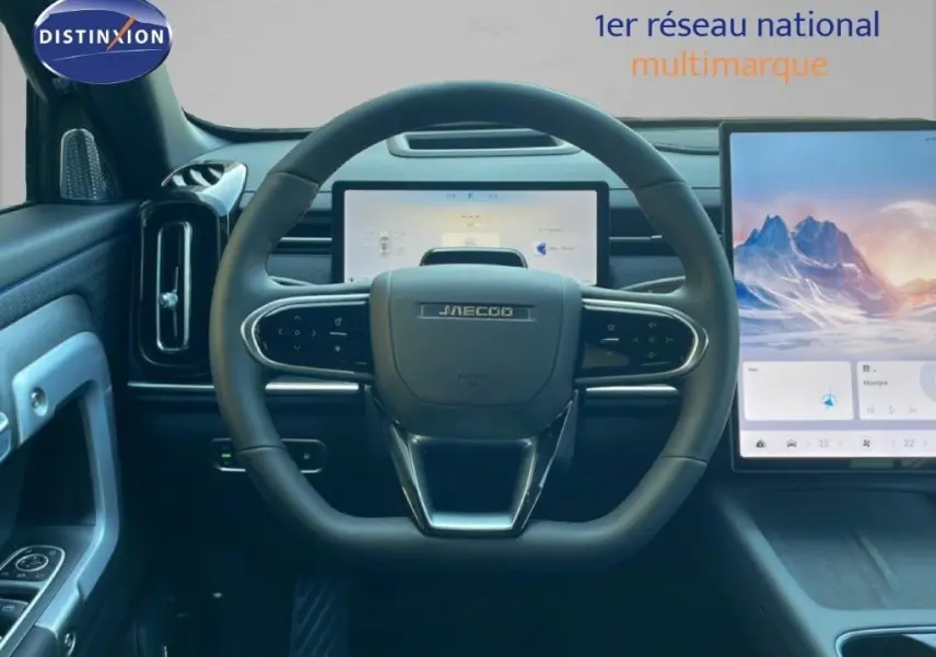 Vue intérieure centrée sur le volant JAECOO noir avec tableau de bord numérique et écran tactile latéral.