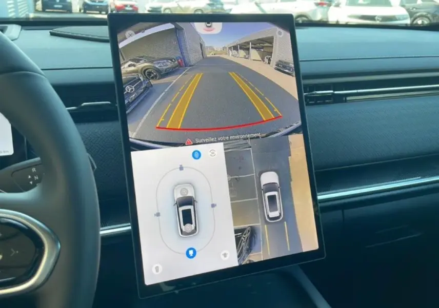 Vue intérieure du tableau de bord du JAECOO J7 2026 avec écran tactile affichant la caméra de recul et vue à 360°, intérieur noir.