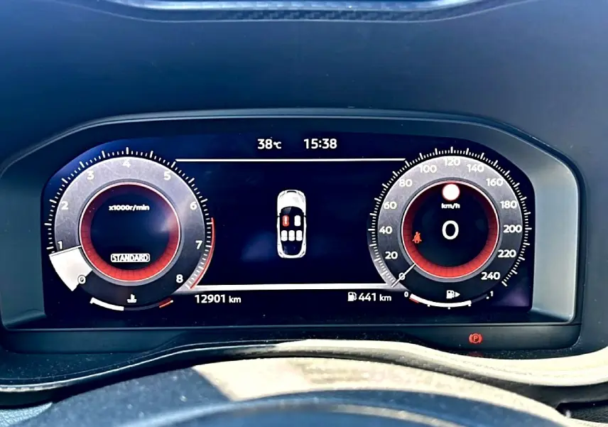 Vue rapprochée du tableau de bord numérique du Nissan Juke gris, affichant compte-tours et vitesse à 0 km/h.
