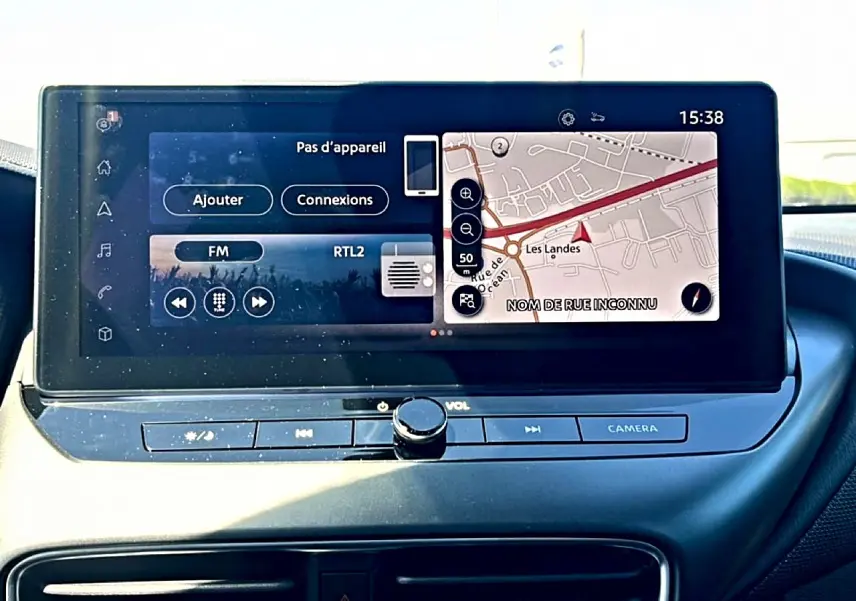 Écran tactile central du tableau de bord du Nissan Juke 2025 affichant navigation et radio FM.