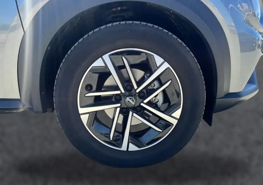 Gros plan sur la jante alu noire et argentée du côté avant droit du Nissan Juke gris 2025.