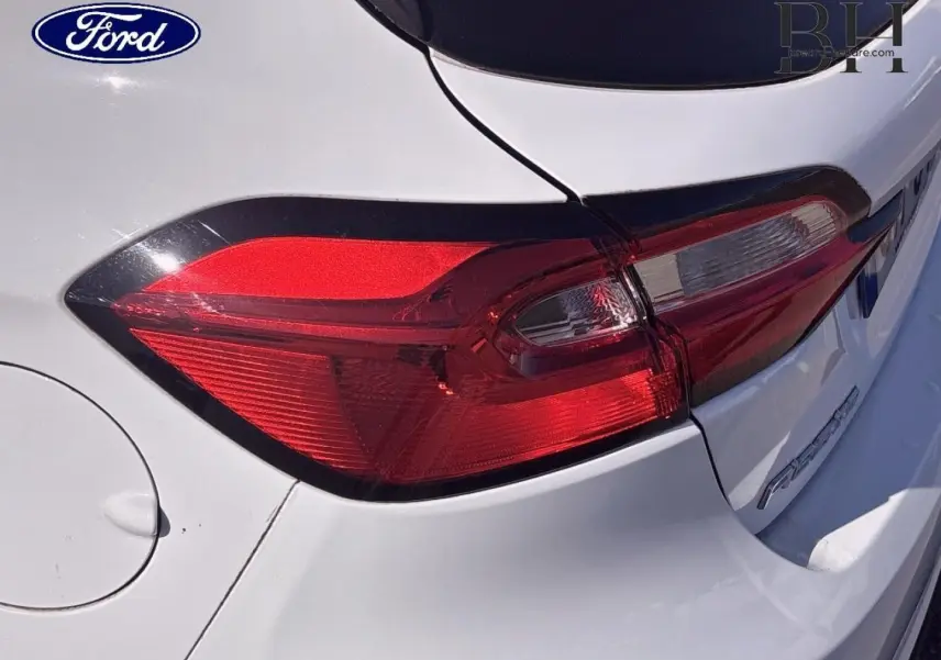 Gros plan sur le feu arrière gauche d'une Ford Fiesta 2023 blanc glacier, mettant en valeur la carrosserie et les lignes arrière.
