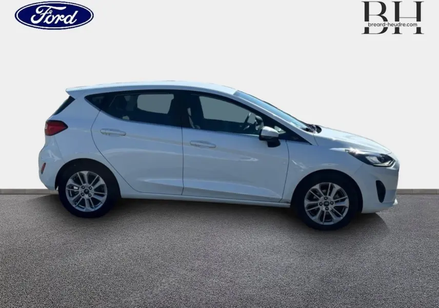 Profil droit d'une Ford Fiesta 2023 blanc glacier avec jantes alu et poignées ton carrosserie visibles.