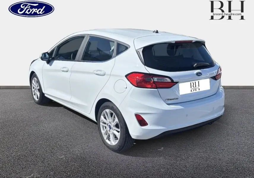 Vue 3/4 arrière droite d'une Ford Fiesta blanc glacier avec jantes alu et feux arrière LED distinctifs.