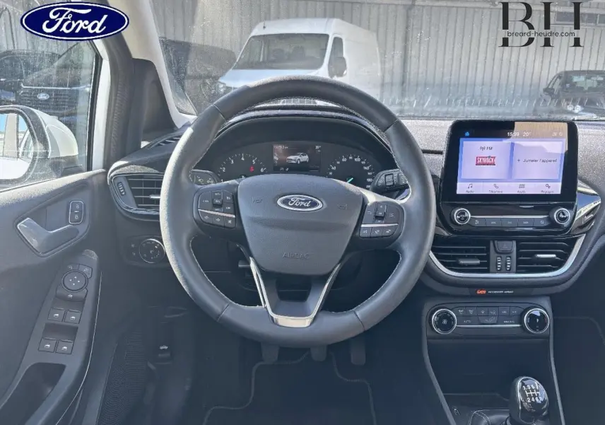 Vue intérieure centrée sur le volant cuir et tableau de bord avec écran tactile de la Ford Fiesta Titanium Business 2023.