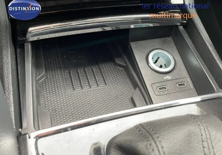 Gros plan sur la console centrale noire du Skoda Karoq avec prise USB et espace de rangement.