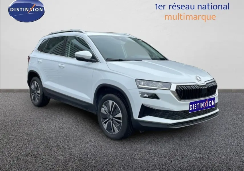 Vue 3/4 avant droite du Skoda Karoq blanc glacier avec jantes bi-ton et vitres arrière surteintées.