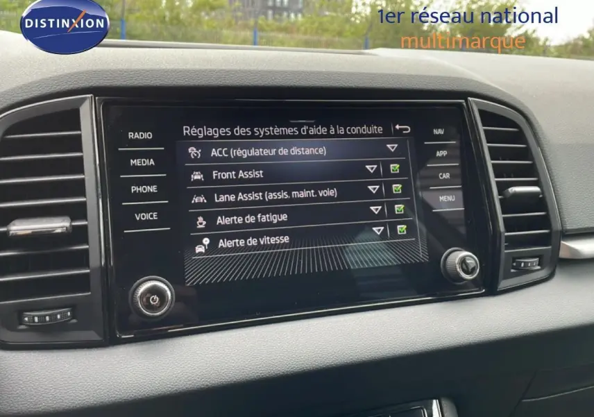 Écran tactile intérieur SKODA KAROQ blanc glacier 2025 montrant les aides à la conduite activées.