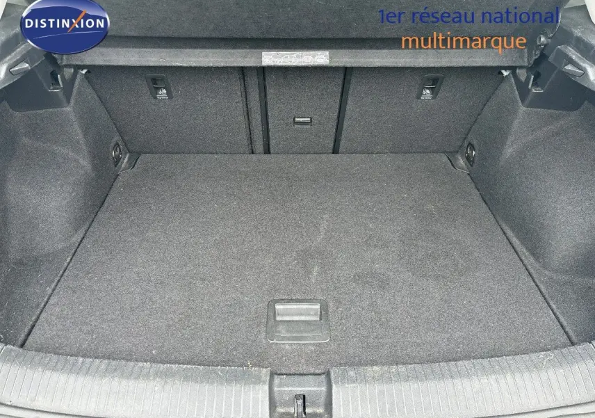 Coffre spacieux du Volkswagen T-Roc blanc argenté, vue intérieure depuis l'arrière avec banquette rabattable visible.