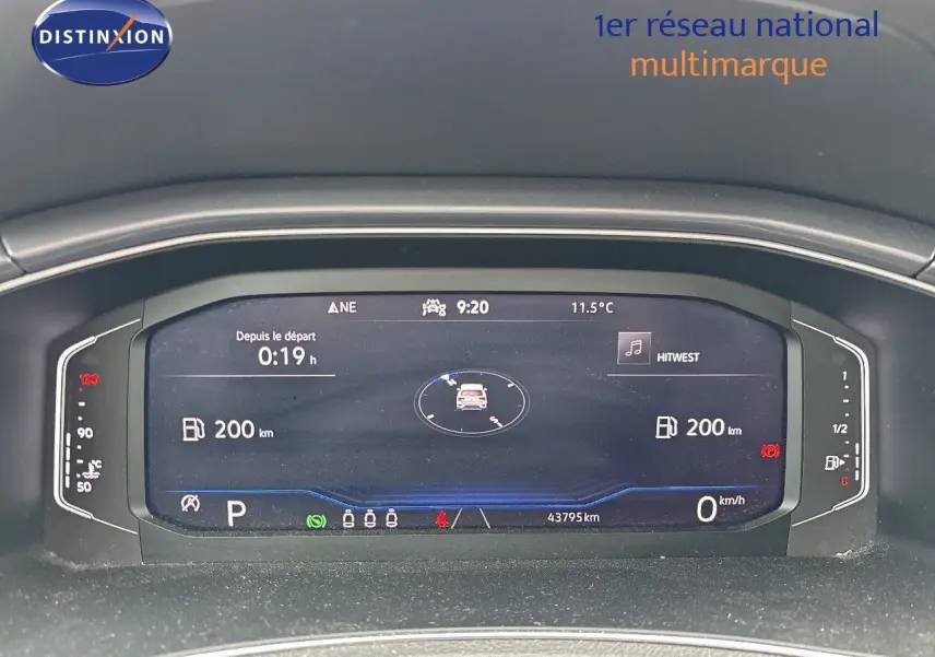 Tableau de bord numérique du Volkswagen T-Roc blanc, affichant la vitesse, autonomie et température extérieure.