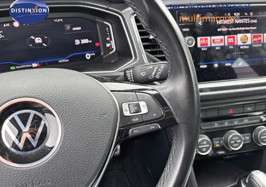 Vue rapprochée du volant en cuir noir et du tableau de bord numérique du Volkswagen T-Roc blanc Silver 2021.