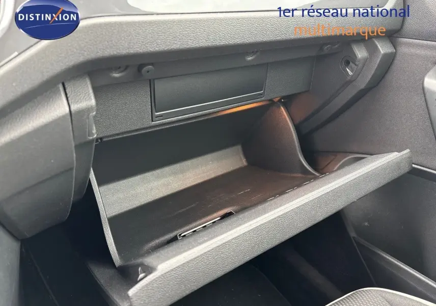 Vue 3/4 avant droit du Volkswagen T-Roc blanc argenté 2021 avec jantes alliage et feux LED allumés.