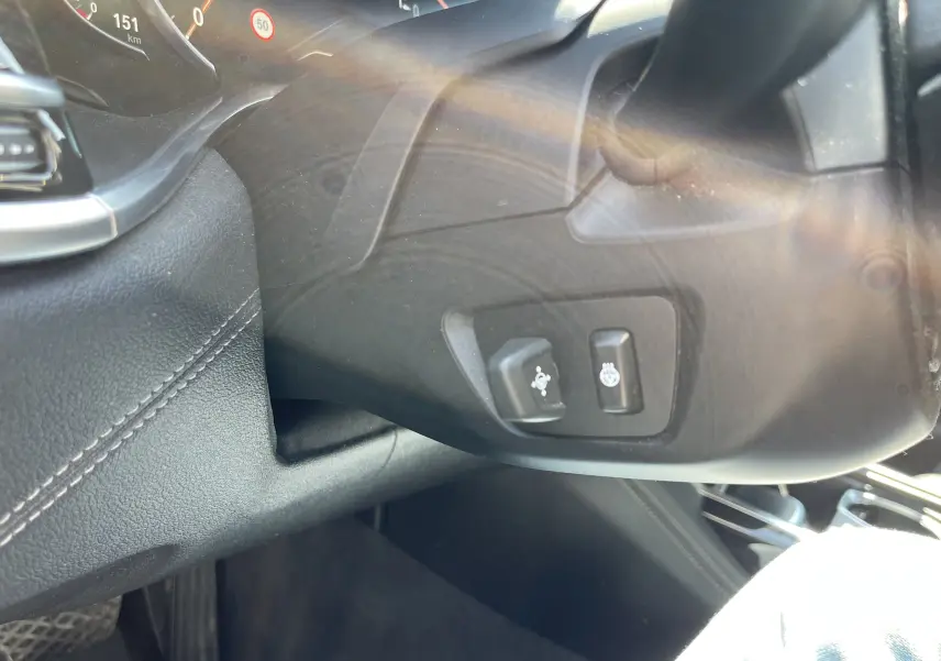 Détail du tableau de bord noir côté gauche d'une BMW Série 7 G11 avec commandes de réglage du volant et chauffage intégré.