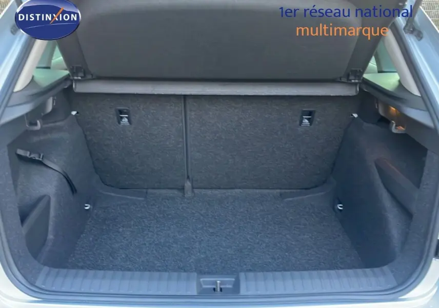 Coffre ouvert vu de l'arrière d'un Skoda Kamiq gris argent métallisé, montrant l'espace de chargement vide.