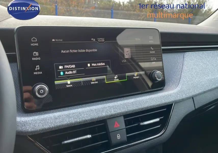 Intérieur du Skoda Kamiq 1.0 TSI gris argent, vue sur l'écran tactile central et la console de bord moderne.